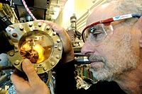 Argonne chemist Richard Rosenberg examines source material for an experiment to induce chirality into pre-biological systems at the Advanced Photon Source. Rosenberg used X-ray photoelectron spectroscopy to measure the secondary electron induced photolysis reaction rate of a model chiral compound adsorbed on a magnetic substrate. He found that changing the magnetization direction in relation to the high-intensity X-ray beam created an excess of one chirality over another.