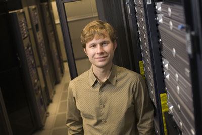 Jason Koski/University Photography
CNF computational research associate Derek Stewart stands in front of the CNF computer cluster in Rhodes Hall. His research in nanoscale heat transfer may someday allow such server farms to have cooling systems without fans.