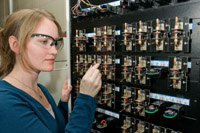 Argonne researcher Lynn Trahey loads a coin-sized cell on a testing unit used to evaluate electrochemical cycling performance in batteries. (Larger hi-rez version.) Photo by Wes Agresta.