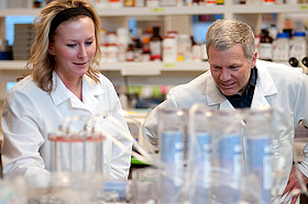 Abby Leary and Jim Wiley work with an aerosolization chamber used to innoculate the lung. (MSU photo by Kelly Gorham).