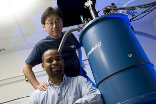 Rice University Professor Junichiro Kono, standing, and graduate student Thomas Searles set out to study interactions between magnetic fields and electrically charged particles and found that strong magnets can stop the flow of electrons through metallic single-walled carbon nanotubes. (Credit Jeff Fitlow/Rice University)