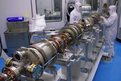 Cornell employees James Sears and Don Heath work in the Newman Laboratory cleanroom assembling the superconducting radio-frequency cavity accelerating structure for the ERL injector prototype.