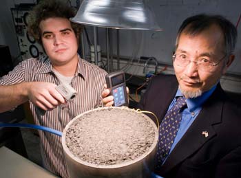 URI student Andrew Correia and Professor K. Wayne Lee conduct a laboratory experiment to measure the solar energy generated by a patch of asphalt. URI Department of Communications & Marketing photo by Michael Salerno Photography.