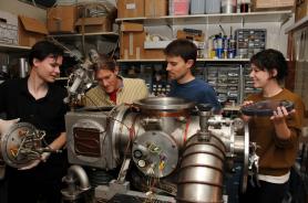 Graduate student Vincent Lonij (left), associate professor of physics Alex Cronin, research assistant Will Holmgren and undergraduate student Catherine Klauss perform maintenance on a chamber used to beam atoms through a grating to measure a tiny force that helps physicists better understand the structure of atoms. (Photo by Norma Jean Gargasz/UANews)