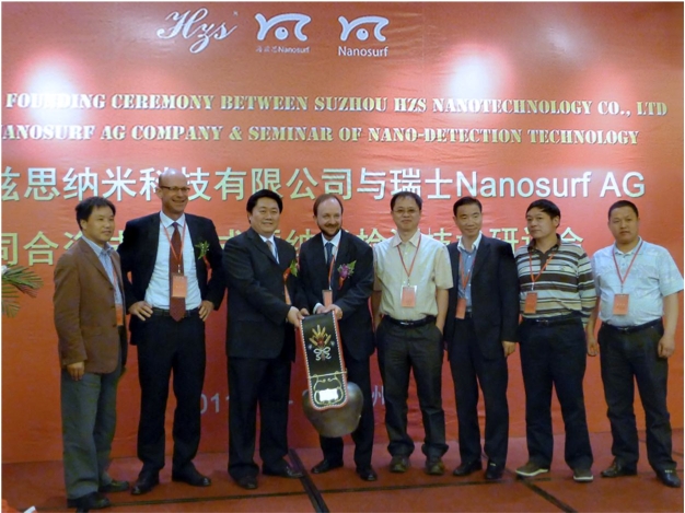 Dr. Urs Matter, CEO of Nanosurf (2nd on the left) and Dr. Lukas Howald, chairman of the board for Nanosurf (4th on the left) hand over a present of Swiss culture to Dr. Luo, CEO of Hzs (3rd on the left). Several representatives of Chinas higher education institutions and members of the Chinese Ministry of Education took part in the celebration event at Suzhou Industrial Park.