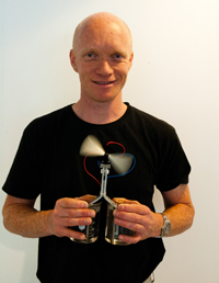 HOT AND COLD WATER: Ole Martin Lvvik demonstrates thermoelectricity with one glass of cold and one glass of hot water. The new technology utilises the temperature difference and generates enough energy to operate a rapidly rotating fan. Foto: Yngve Vogt