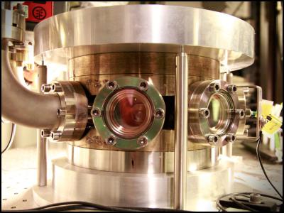 The experiments themselves are carried out in this vacuum chamber. When the laser light hits the membrane, some of the light is reflected and some is absorbed and leads to a small heating of the membrane. The reflected light is reflected back again via a mirror in the experiment so that the light flies back and forth in this space and forms optical resonator (cavity). Changing the distance between the membrane and the mirror leads to a complex and fascinating interplay between the movement of the membrane, the properties of the semiconductor and the optical resonances and you can control the system so as to cool the temperature of the membrane fluctuations.

Credit: Niels Bohr Institute