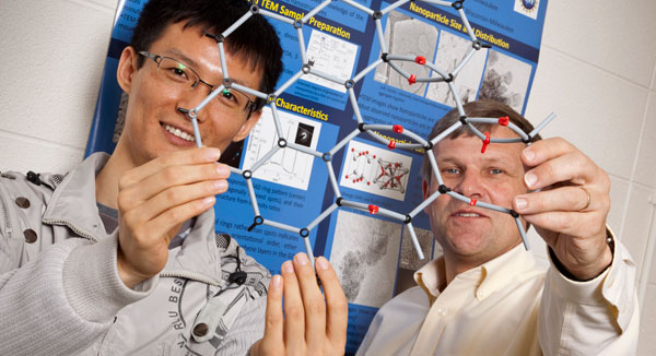 Physics Professor Michael Weinert and engineering graduate student Haihui Pu display the atomic structure on GMO. (Photos by Alan Magayne-Roshak)