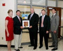 (L-R) Ann Decker, Executive Director, Indian River State College (IRSC) Foundation; Dr. Edwin Massey, President, IRSC; Dean Hart, Chief Commercial Officer, NanoInk; Dr. Kevin Cooper, Director of Advanced Technology, IRSC; Jason Fromer, Global Business Development Executive, NanoProfessor, stand in front of the NanoProfessor Advanced Materials Lab at Indian River State College. At the dedication of the NanoProfessor Advanced Materials Lab, Dean Hart presented a framed image of the smallest IRSC logo in existence to Dr. Edwin Massey. The actual logo was printed with NanoInk's Dip Pen Nanolithography and is 10 x 10 microns consisting of 6,500, 20 nanometer dots. Approximately 17,000 copies of the micron-sized IRSC logo will fit on the head of a pin.