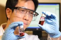 Georgia Tech professor Zhiqun Lin examines a gold nanoparticle toluene solution. The work is part of research on using star-shaped block co-polymers to create nanocrystals of uniform size and shape.

Credit: Georgia Tech Photo: Gary Meek