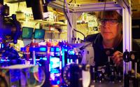 Georgia Tech professor Michael Chapman poses with laser equipment in his laboratory. Georgia Tech researchers have demonstrated a way to maintain an unstable quantum system by applying bursts of microwave radiation.

Credit: Georgia Tech Photo: John Toon