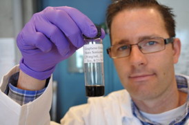 Jacob D. Lanphere, a Ph.D. student at UC Riverside, holds a sample of graphene oxide.