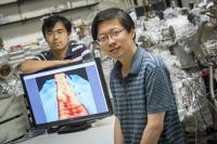 Yaoyi Li (foreground) and Mingxing Chen, UWM physics postdoctoral researchers, display an image of a ribbon of graphene 1 nanometer wide. In the image, achieved with a scanning-tunneling microscope, atoms are visible as "bumps."

Credit: Troye Fox, UWM Photo Services