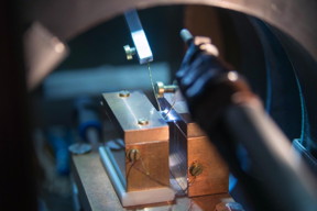 In this experimental design, the sample is stretched between two copper blocks. One is hot; the other, cold. The coils generate the magnetic field; the contact pins measure the tension.

Photo: Bielefeld University