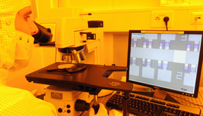 Mirko Hansen when checking the memory cells produced by a microscope in the clean room of the Kiel School of Engineering. 
Photo / Copyright: AG nanoelectronics