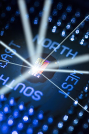 This packaged electronic-photonic processor microchip under illumination reveals the chip's primary features. The light rays emanating from the chip are drawn to show that the processor talks to the outside world using light.

Image by Glenn J. Asakawa, University of Colorado, Glenn.Asakawa@colorado.edu