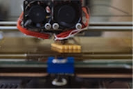 A 3-D printer sketches out a schwarzite in a Rice University laboratory. The curved surface of a schwarzite repeats throughout the structure, which shows excellent strength and deformation characteristics. (Credit: Brandon Martin/Rice University)

