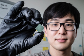 
Illinois mechanical science and engineering student and lead author of a new study Benjamin Sohn holds a device that uses sound waves to produce optical diodes tiny enough to fit onto a computer chip.

Photo by L. Brian Stauffer