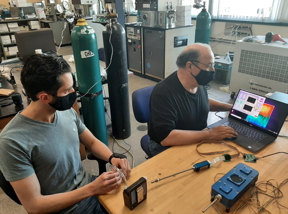 URI doctoral student Peter Ricci (left) and Professor Otto Gregory test the Digital Dog Nose sensors platform in Gregory's Thin Film Sensors Laboratory at URI. The blue devices on the table represent the two latest versions of the Digital Dog Nose.

CREDIT
Photo by Mike Platek